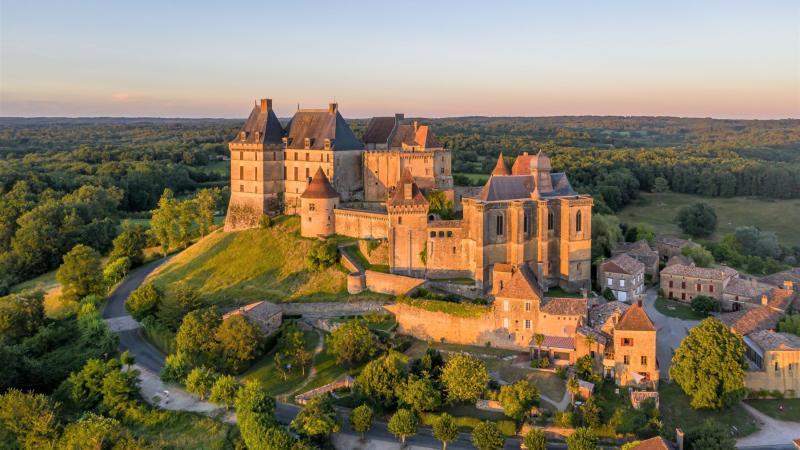 Vue aérienne du château de Biron et de son village, au printemps