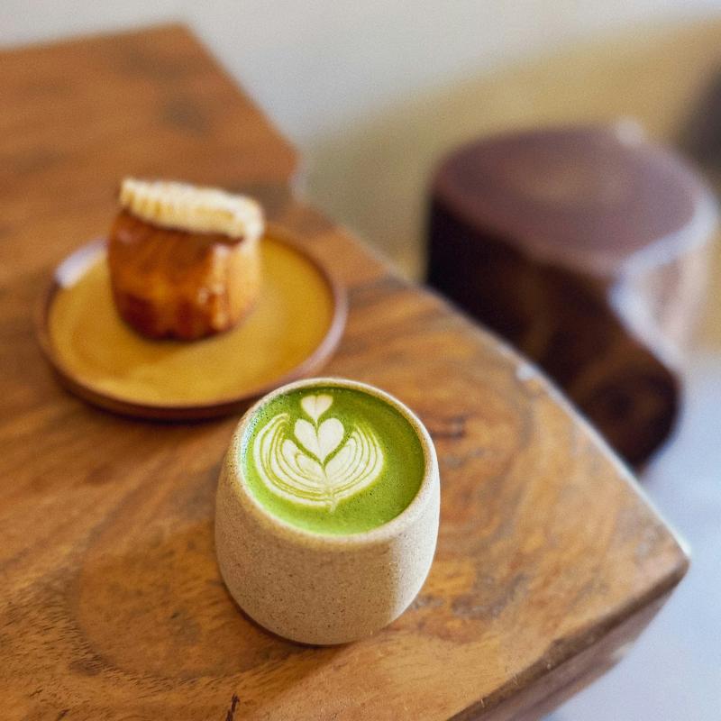 Une tasse de thé vert en céramique, sur une table en bois